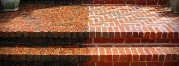 Dramatic transformation of brick stairs in Cumming with pressure washing that removed dark stains, algae, and grime to reveal fresh, bright brick steps