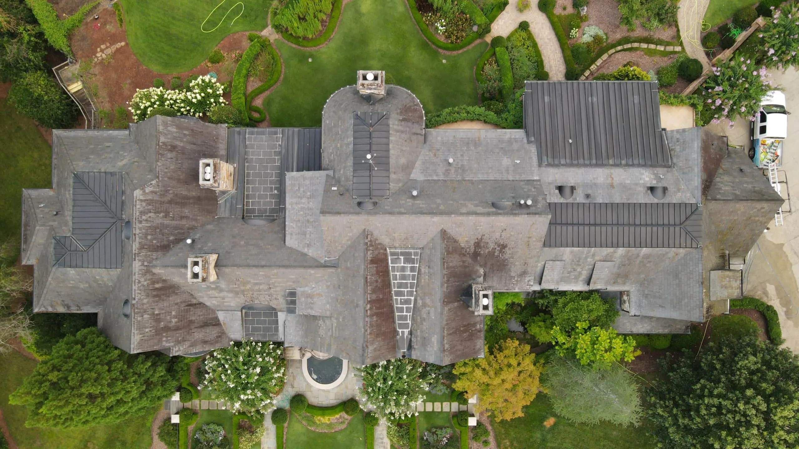 Commercial Roof Cleaning Before & After Aerial view of large commercial roof showing dramatic contrast between dirty and freshly cleaned sections, highlighting the power of pressure washing service
