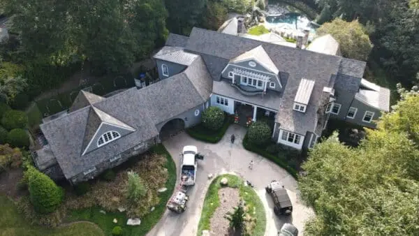 Aerial view of a home showing algae growth on roof shingles. Learn what causes algae on roofs and how professional cleaning helps maintain curb appeal and value