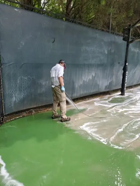 HOA Court Pressure Washing in Progress Technician performing pressure washing on HOA basketball court, removing dirt and algae buildup to restore a clean, safe play surface in Alpharetta GA