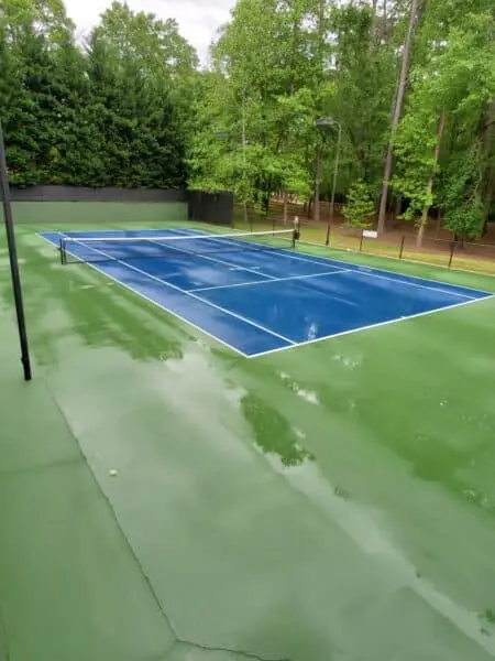 HOA Tennis Court After Power Washing Freshly cleaned HOA tennis court with spotless green and blue surfaces, showcasing the results of expert exterior cleaning and court restoration