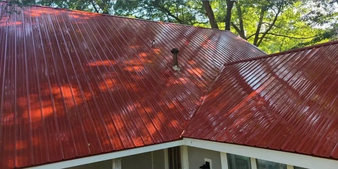 Red Metal Roof Restored to Glossy Finish Pressure washed red metal roof restored to like-new shine by removing grime and debris, enhancing appearance and protecting surface from damage