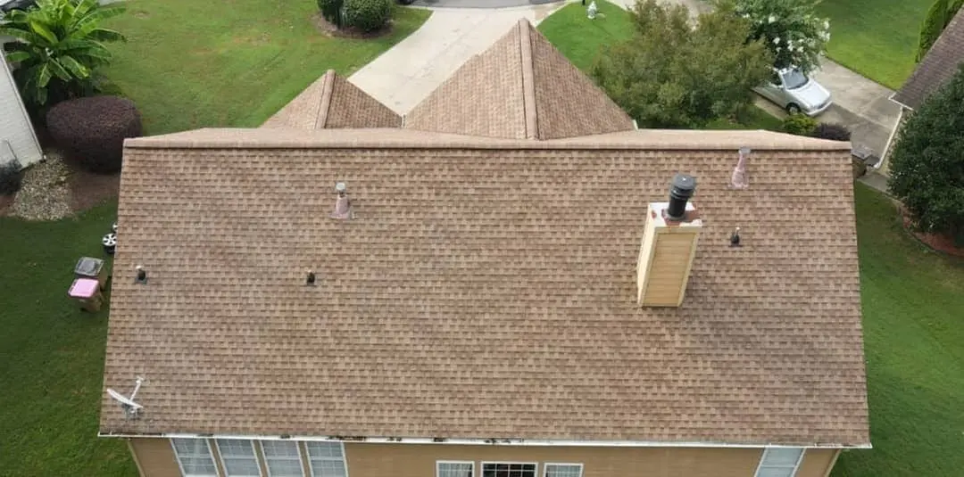 Aerial shot of a spotless roof surrounded by lush greenery shows the impact of expert pressure washing on curb appeal and property maintenance