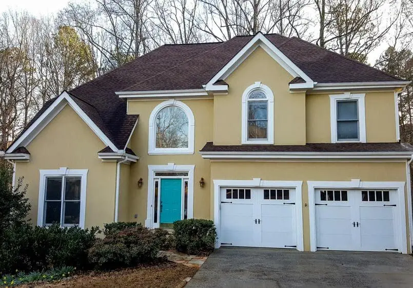 Clean stucco house after gutter service Aqua-Nomics completed gutter cleaning on a stucco home in Metro Atlanta restoring clean lines and protecting against water damage