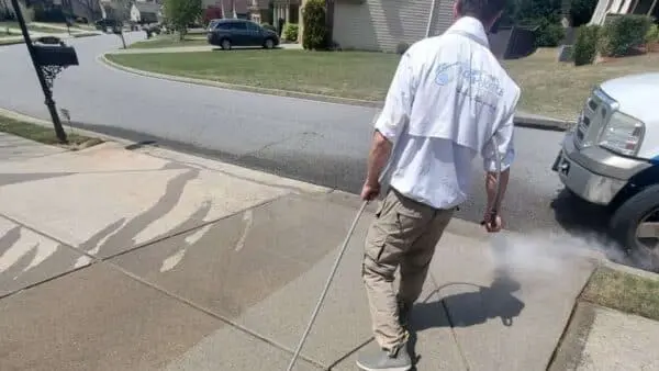Aqua-Nomics technician performs sidewalk power washing to enhance the professional look and cleanliness of a commercial property’s exterior entrance