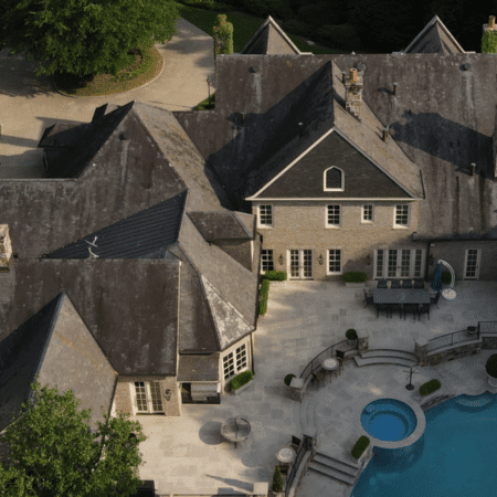 Aerial view of slate roof covered in dark stains and buildup—ideal example of what Aqua-Nomics can restore with expert roof cleaning services