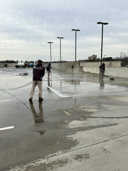 A Team Of Professionals Doing Pressure Washing On Parking Decks