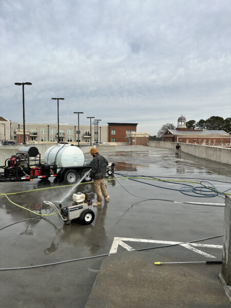 An Expert Cleaning Parking Lot With Pressure Washing